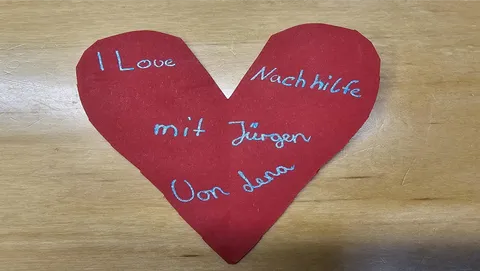 Lena hat auf ein ausgeschnittenes Herz aus Tonpapier einen Gruß an Jürgen geschrieben